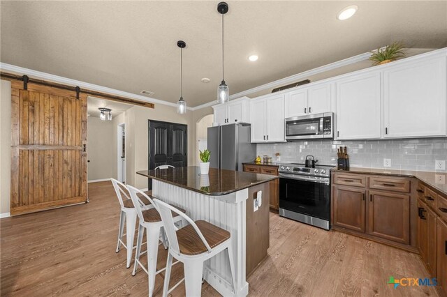 1442 Neff Dr, Copperas Cove, TX 76522 - kitchen with stainless steel appliances, light wood-type flooring, ornamental molding, a kitchen breakfast bar, and a kitchen island