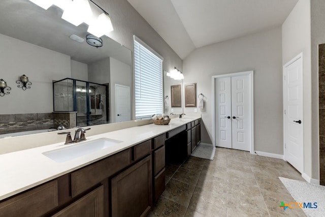 bathroom featuring an enclosed shower, vanity, and vaulted ceiling