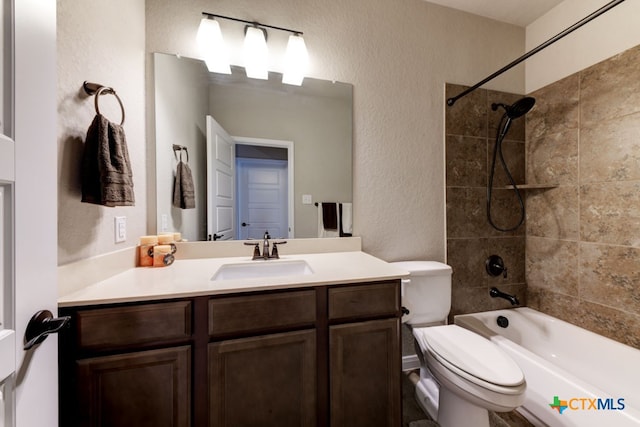 full bathroom with vanity, tiled shower / bath, and toilet