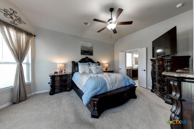 bedroom featuring lofted ceiling, light carpet, ceiling fan, and ensuite bath