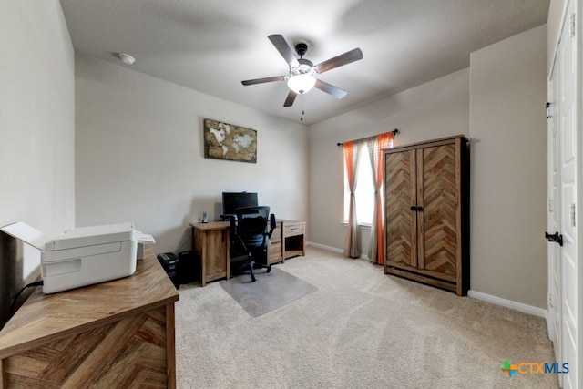 carpeted office space with ceiling fan