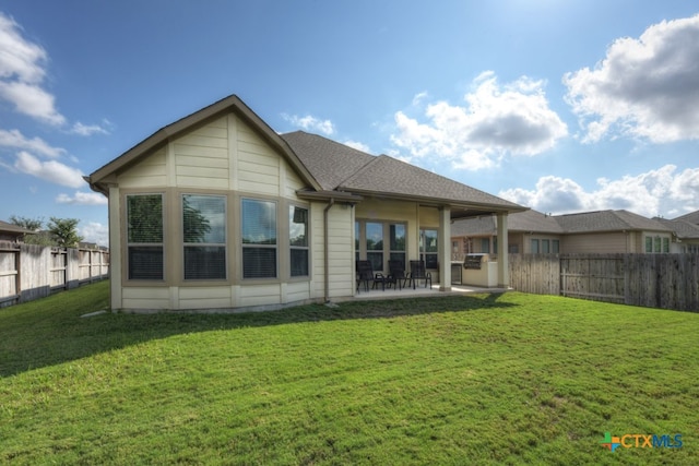 rear view of property featuring a patio and a lawn