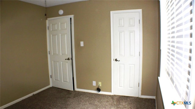 unfurnished bedroom with dark carpet