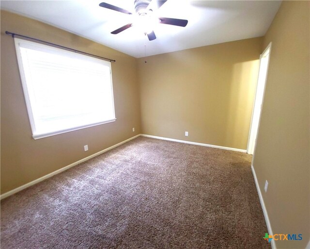 carpeted spare room with ceiling fan