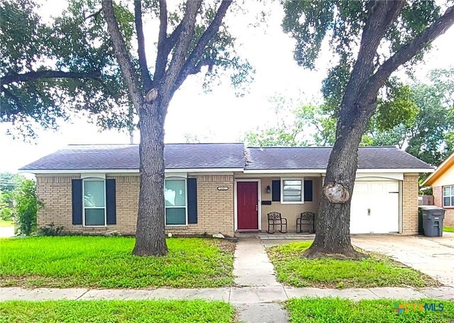 4601 Evergreen Ln, Victoria, TX 77904 - ranch-style home with an attached garage, brick siding, concrete driveway, and a front yard