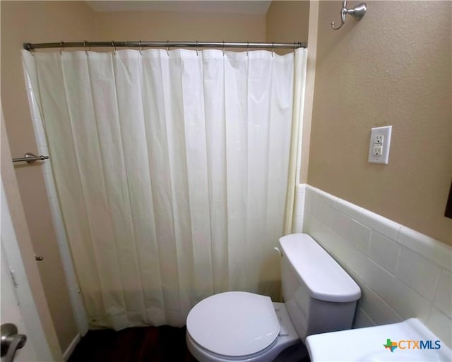 4601 Evergreen Ln, Victoria, TX 77904 - bathroom with a wainscoted wall, a shower with shower curtain, tile walls, and vanity