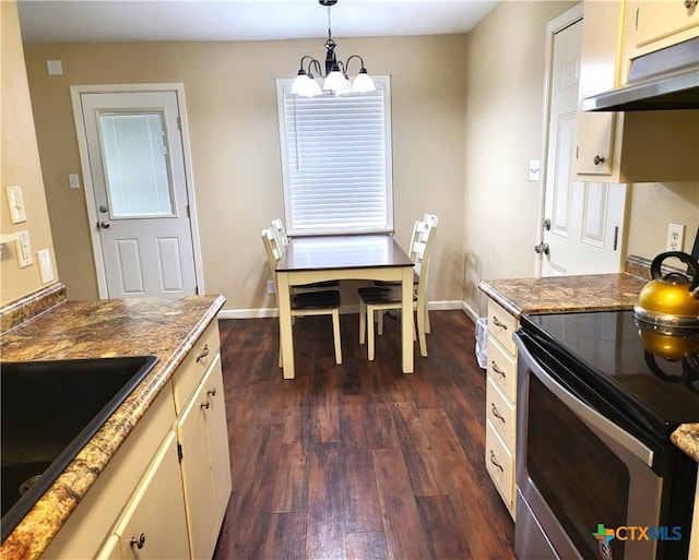 kitchen with decorative light fixtures, a chandelier, dark wood-type flooring, cream cabinetry, and electric range