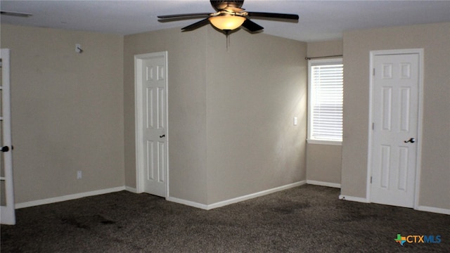 unfurnished bedroom featuring ceiling fan and dark carpet