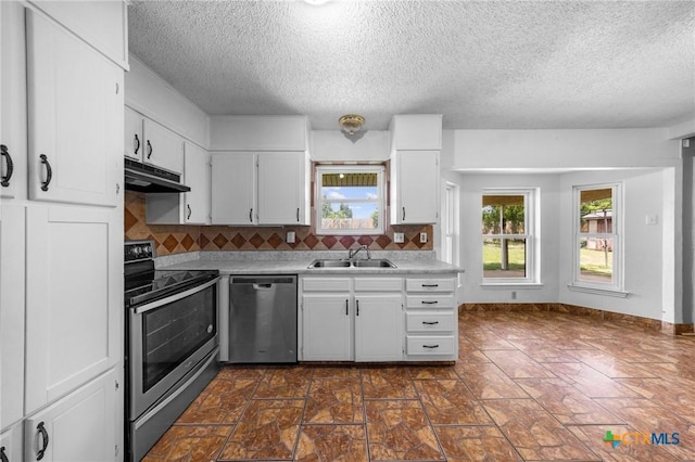 101 E Hogan Dr, Copperas Cove, TX 76522 - kitchen featuring appliances with stainless steel finishes, under cabinet range hood, a textured ceiling, decorative backsplash, and white cabinets