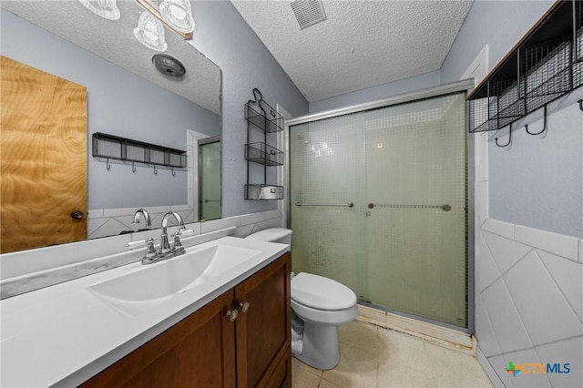 101 E Hogan Dr, Copperas Cove, TX 76522 - full bath featuring a shower stall, vanity, a textured ceiling, wainscoting, and tile walls