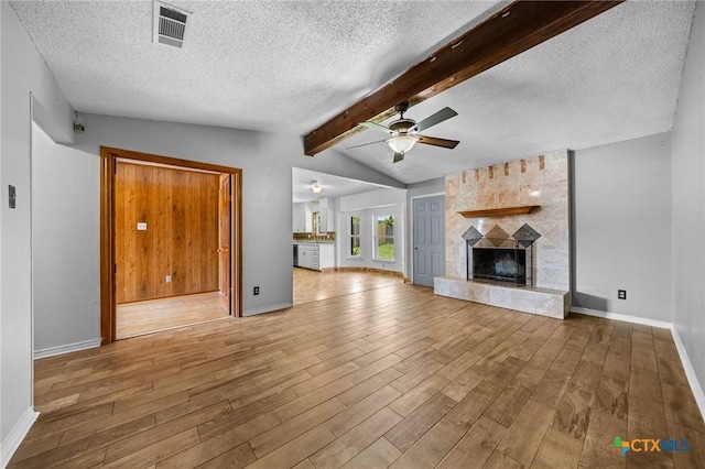 101 E Hogan Dr, Copperas Cove, TX 76522 - unfurnished living room featuring wood finished floors, a textured ceiling, ceiling fan, and a fireplace