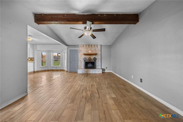 101 E Hogan Dr, Copperas Cove, TX 76522 - unfurnished living room featuring a textured ceiling, a ceiling fan, wood finished floors, and a fireplace