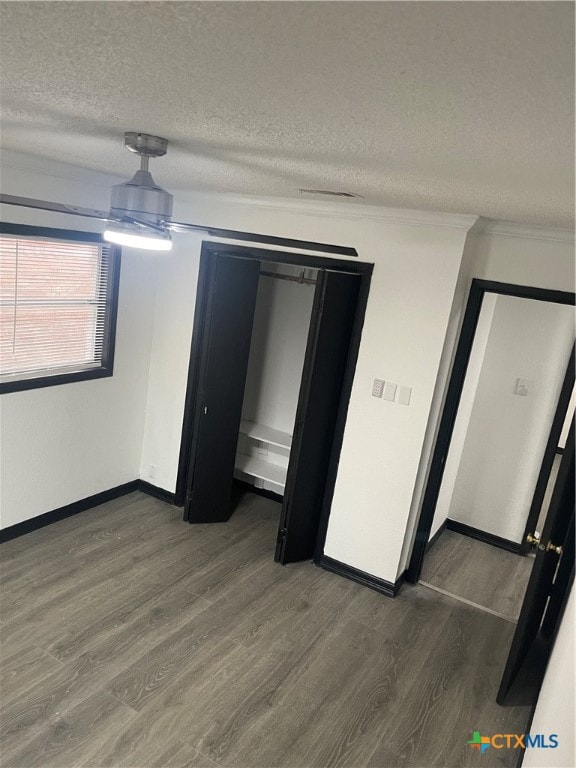 unfurnished bedroom with a textured ceiling and dark hardwood / wood-style floors