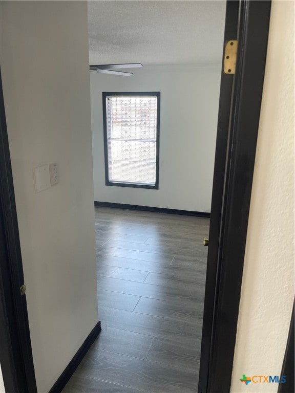 hall featuring dark hardwood / wood-style floors and a textured ceiling