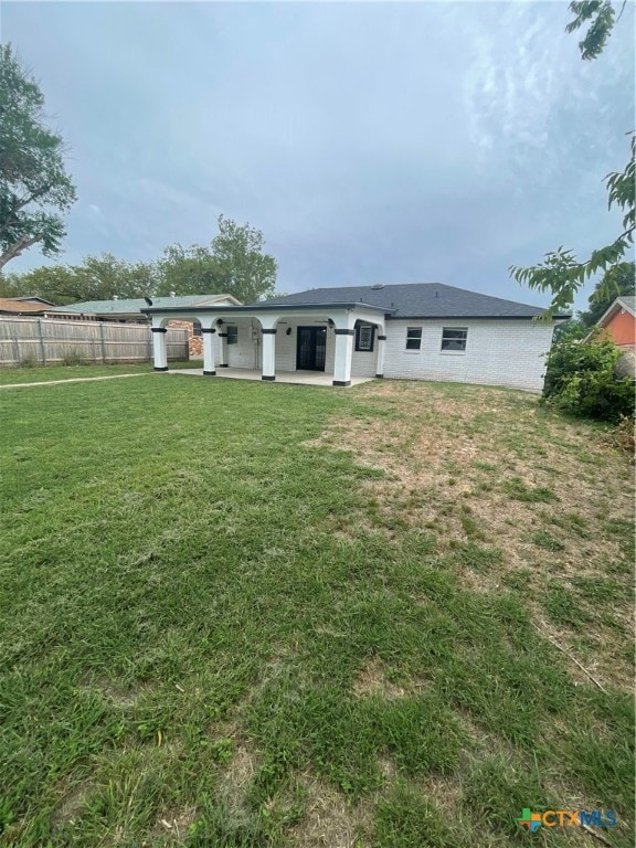 rear view of property featuring a yard