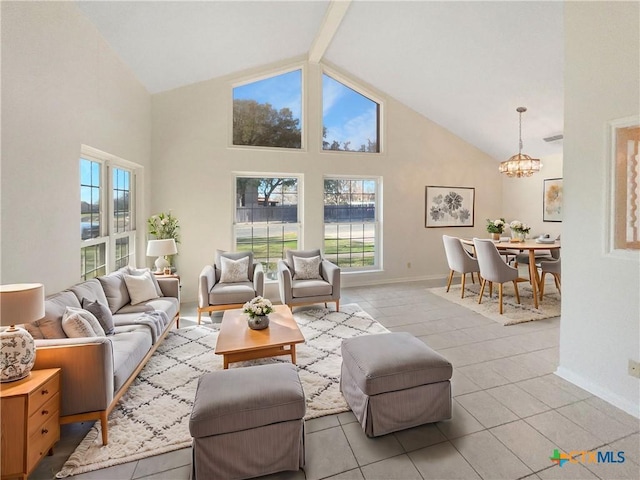 living area with light tile patterned floors, high vaulted ceiling, a healthy amount of sunlight, and a chandelier