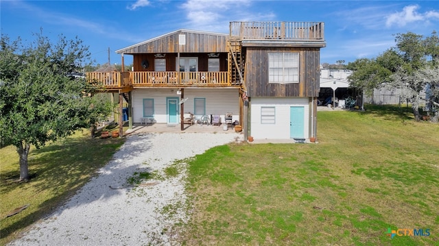 rear view of property featuring a deck and a lawn