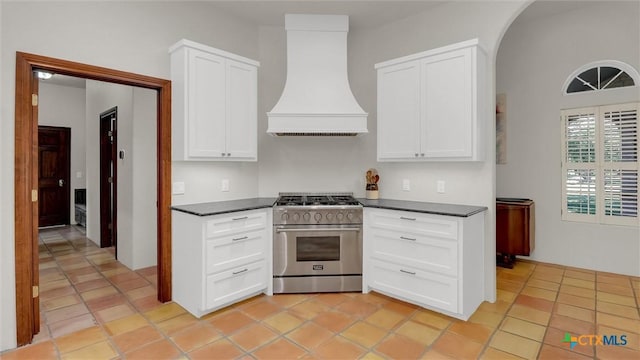 680 Saddleridge Dr, Wimberley, TX 78676 - kitchen featuring high end stove, custom exhaust hood, white cabinets, and dark countertops