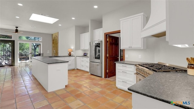 680 Saddleridge Dr, Wimberley, TX 78676 - kitchen with dark countertops, a ceiling fan, stainless steel appliances, and a peninsula