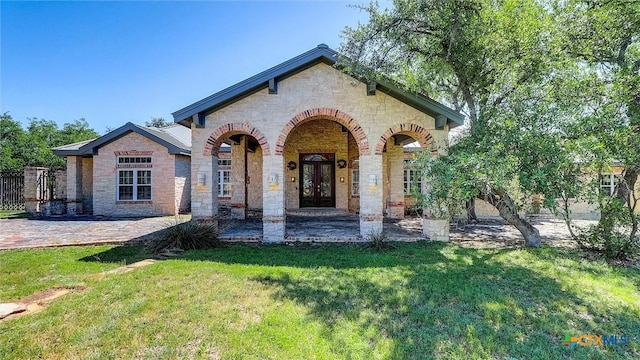 680 Saddleridge Dr, Wimberley, TX 78676 - view of front of home with french doors, covered porch, a front yard, and stone siding