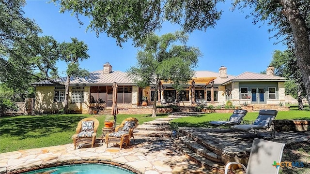 680 Saddleridge Dr, Wimberley, TX 78676 - rear view of house featuring a standing seam roof, a chimney, french doors, and metal roof