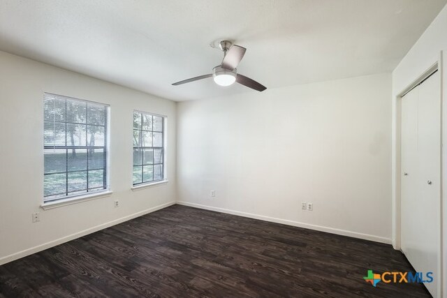 1102/1104/1106 Academy St, San Marcos, TX 78666 - unfurnished bedroom featuring a closet, baseboards, and dark wood-style flooring