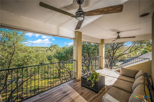 wooden deck featuring ceiling fan and an outdoor living space