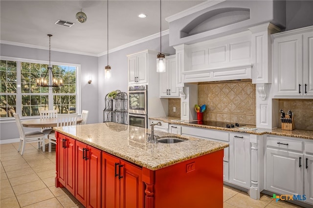 kitchen featuring decorative light fixtures, a center island with sink, black electric cooktop, double oven, and white cabinets