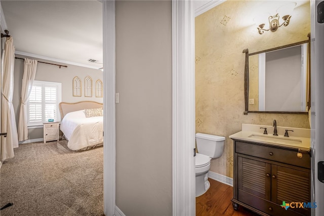 bathroom with crown molding, vanity, and toilet