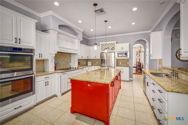 kitchen with a kitchen island with sink, hanging light fixtures, light tile patterned floors, and appliances with stainless steel finishes