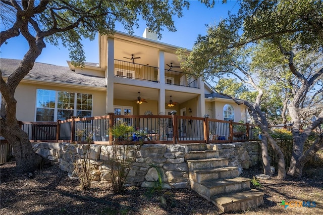 rear view of property featuring ceiling fan and a balcony