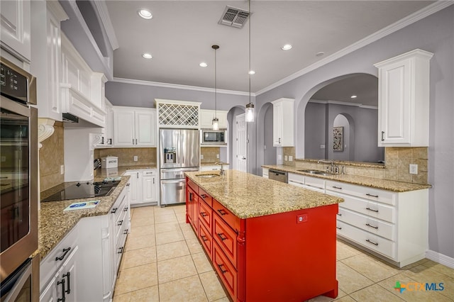 kitchen with light tile patterned flooring, sink, hanging light fixtures, stainless steel appliances, and a center island with sink