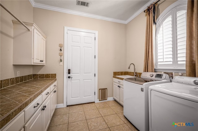 washroom with sink, cabinets, light tile patterned floors, ornamental molding, and washer and clothes dryer