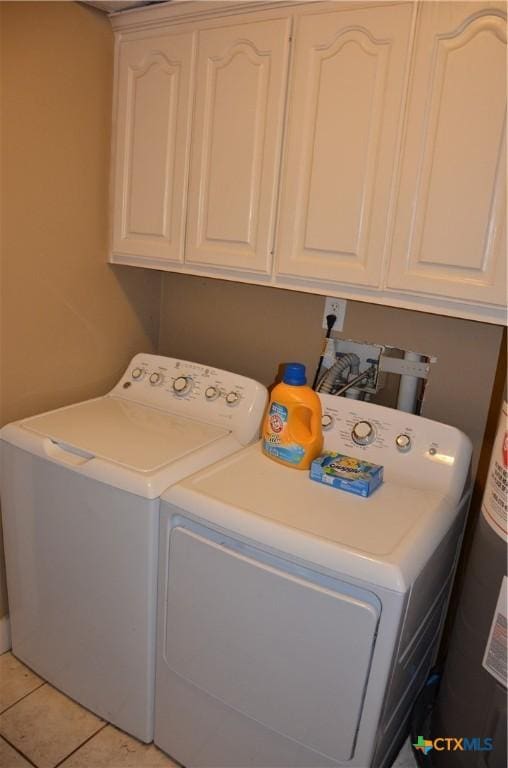 210 Meadow Ln, Martindale, TX 78655 - laundry room with washer and clothes dryer, cabinet space, light tile patterned floors, and water heater