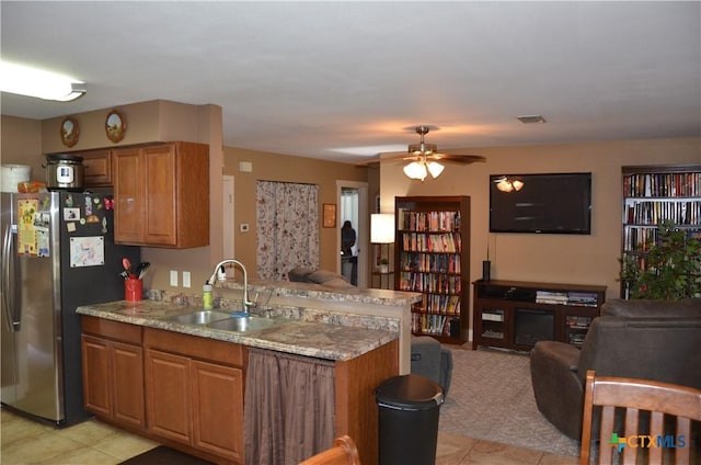 210 Meadow Ln, Martindale, TX 78655 - kitchen with freestanding refrigerator, open floor plan, brown cabinets, and a peninsula
