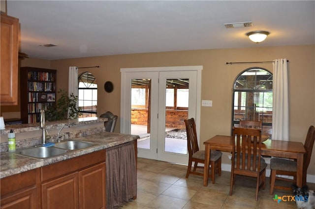 210 Meadow Ln, Martindale, TX 78655 - kitchen featuring healthy amount of natural light, brown cabinetry, light tile patterned floors, and light countertops