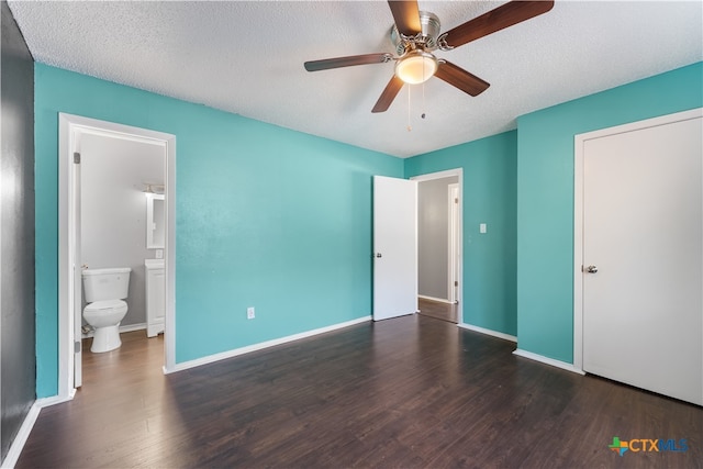 unfurnished bedroom featuring a textured ceiling, dark hardwood / wood-style floors, ensuite bath, and ceiling fan