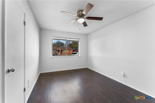 spare room featuring a textured ceiling, ceiling fan, and dark wood-type flooring