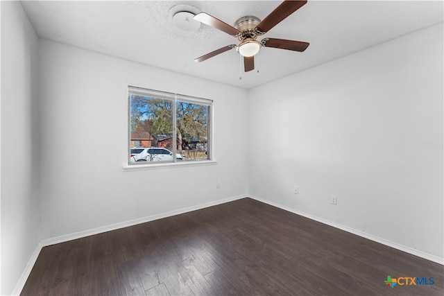 empty room featuring a textured ceiling, ceiling fan, and dark wood-type flooring