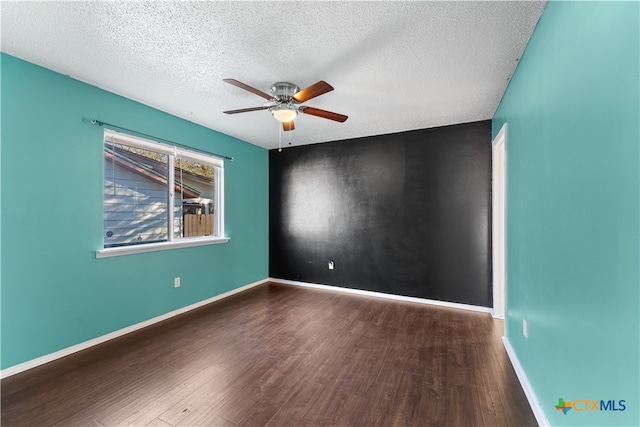 unfurnished room featuring ceiling fan, dark hardwood / wood-style flooring, and a textured ceiling