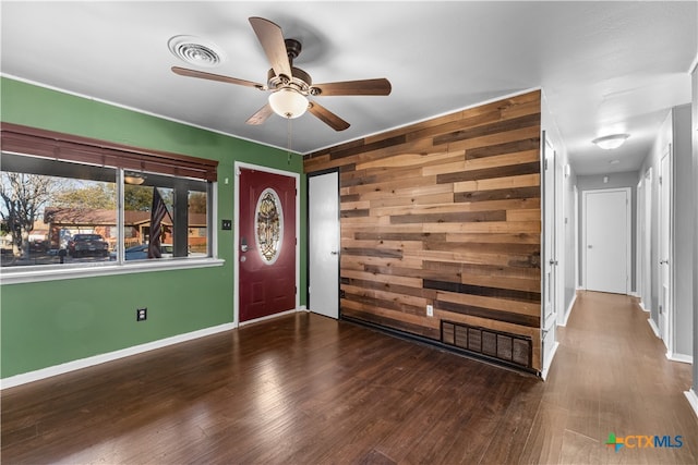 entrance foyer featuring hardwood / wood-style flooring, ceiling fan, and wooden walls