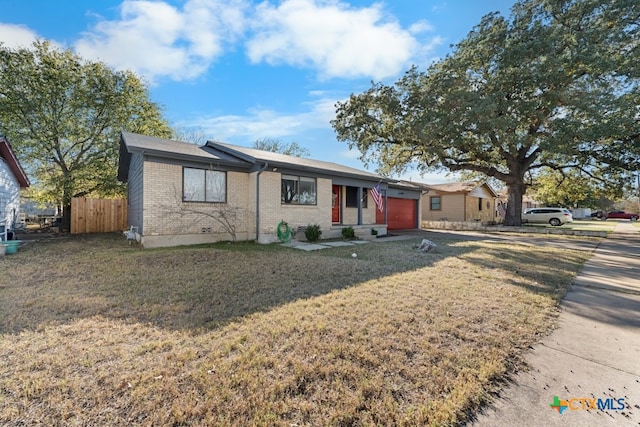 ranch-style home with a garage and a front lawn