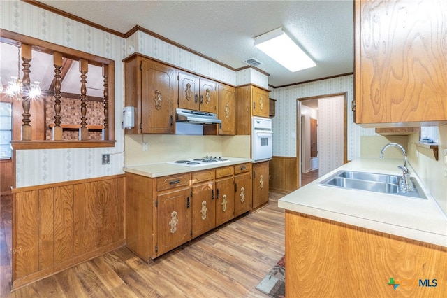 202 Liberty St, Gatesville, TX 76528 - kitchen with white appliances, wallpapered walls, a sink, ornamental molding, and wainscoting