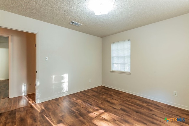 202 Liberty St, Gatesville, TX 76528 - unfurnished room featuring dark wood-style flooring, baseboards, and a textured ceiling