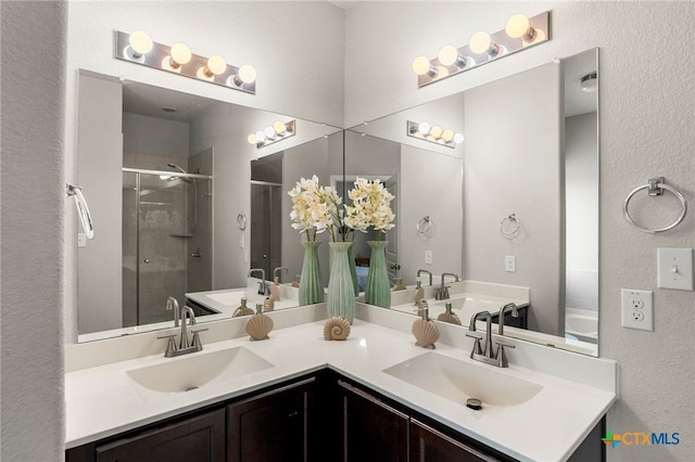 480 Waterloo Dr, Kyle, TX 78640 - full bath with double vanity, a stall shower, and a textured wall