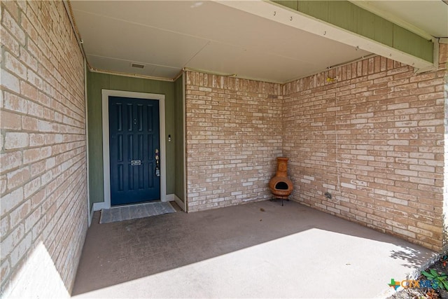 entrance to property featuring brick siding