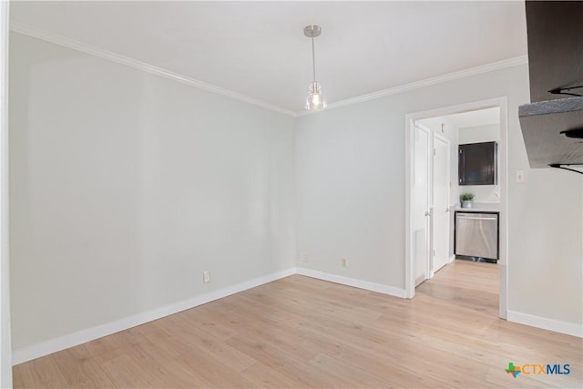 spare room with baseboards, light wood-style flooring, and crown molding