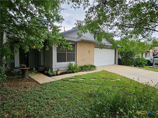 view of front of property with an attached garage, driveway, and a front lawn