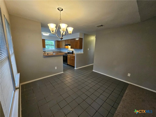 kitchen featuring an inviting chandelier, visible vents, baseboards, dark tile patterned flooring, and gas range oven