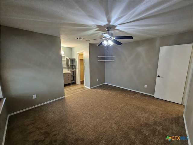 interior space with visible vents, baseboards, a ceiling fan, carpet, and ensuite bath